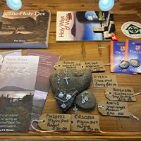 Golwg agos o gwrthrychau ar bwrdd yn son amdan hanes taith pererin